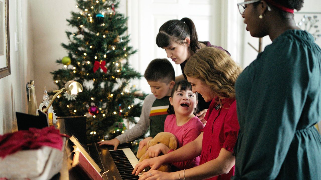 Systermissionärer spelar piano med en familj